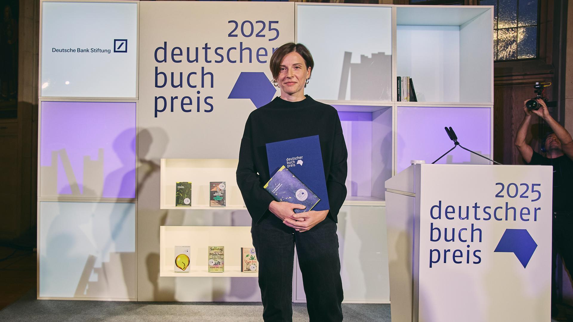 Die Autorin Dorothee Elmiger steht nach der Preisverleihung mit ihrem Buch auf der Bühne.
