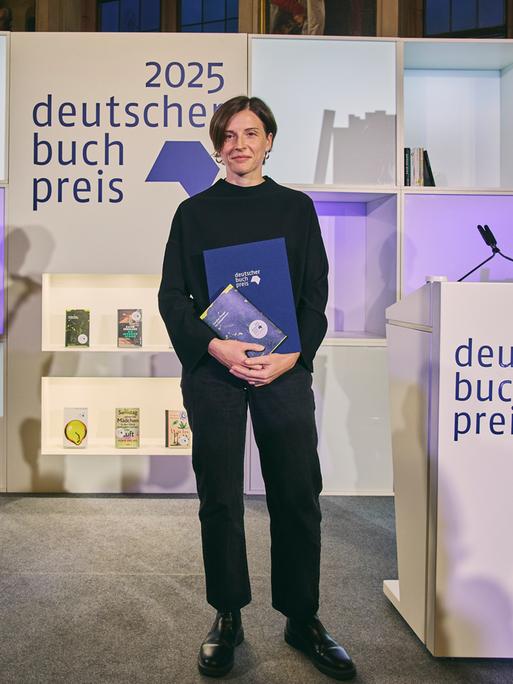 Die Autorin Dorothee Elmiger steht nach der Preisverleihung mit ihrem Buch auf der Bühne.