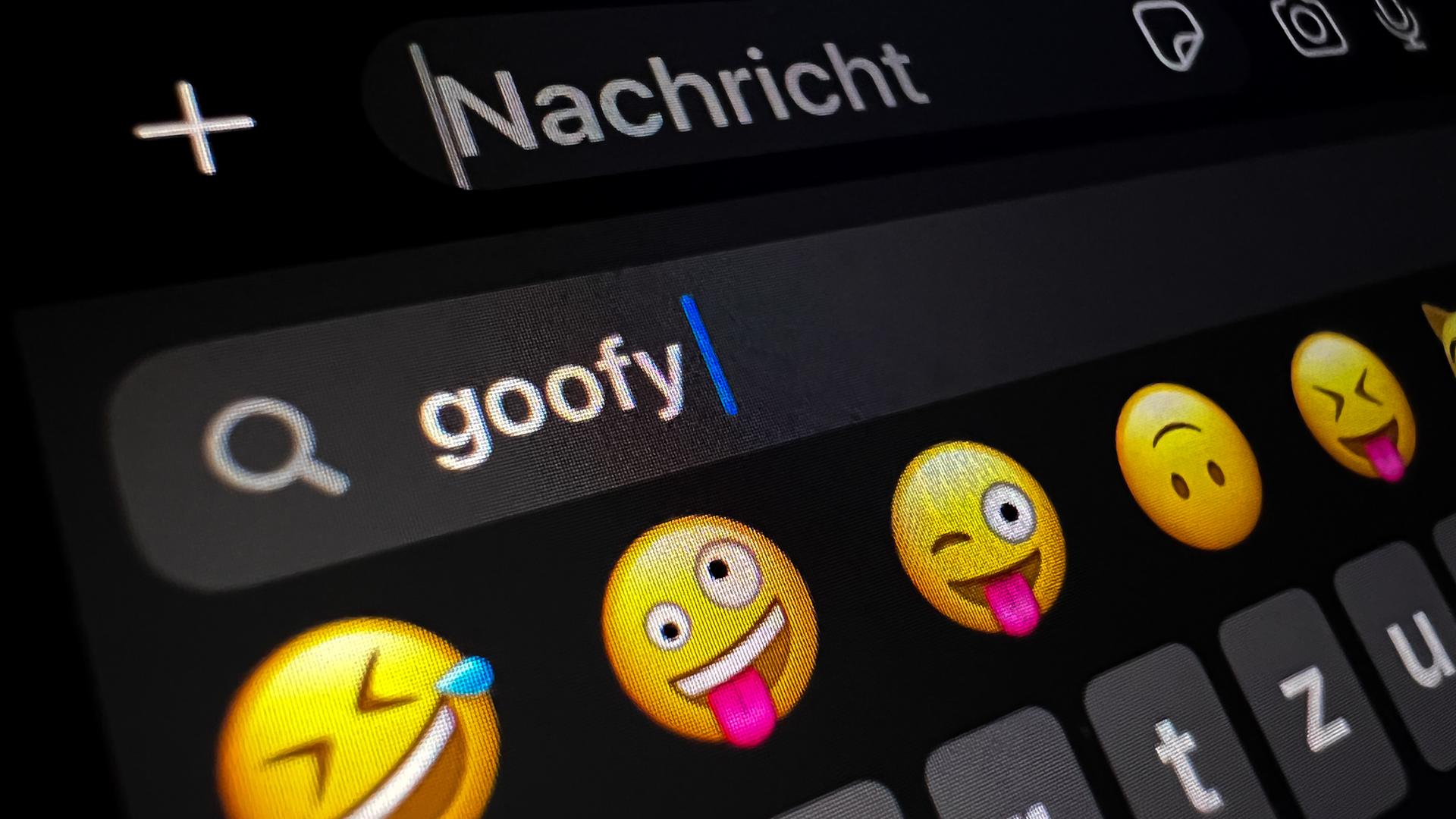 Im Display eines Smartphones ist im Suchfeld für Smileys das Wort "goofy" zu lesen. Es war das "Jugendwort des Jahres" 2023  