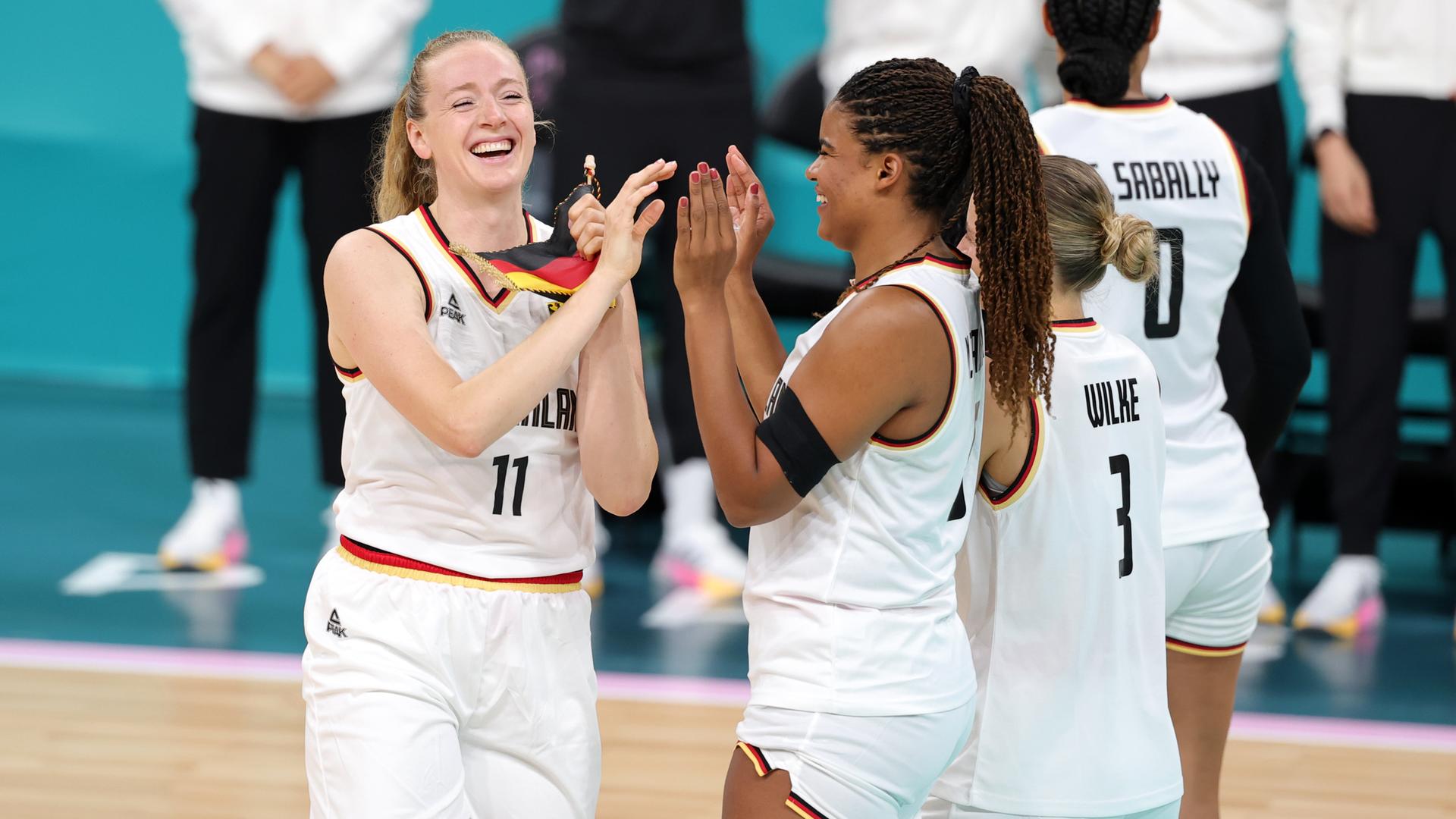 Die deutsche Basketballerin Marie Gülich klatscht mit Nyara Sabally vor einem Spiel ab. 