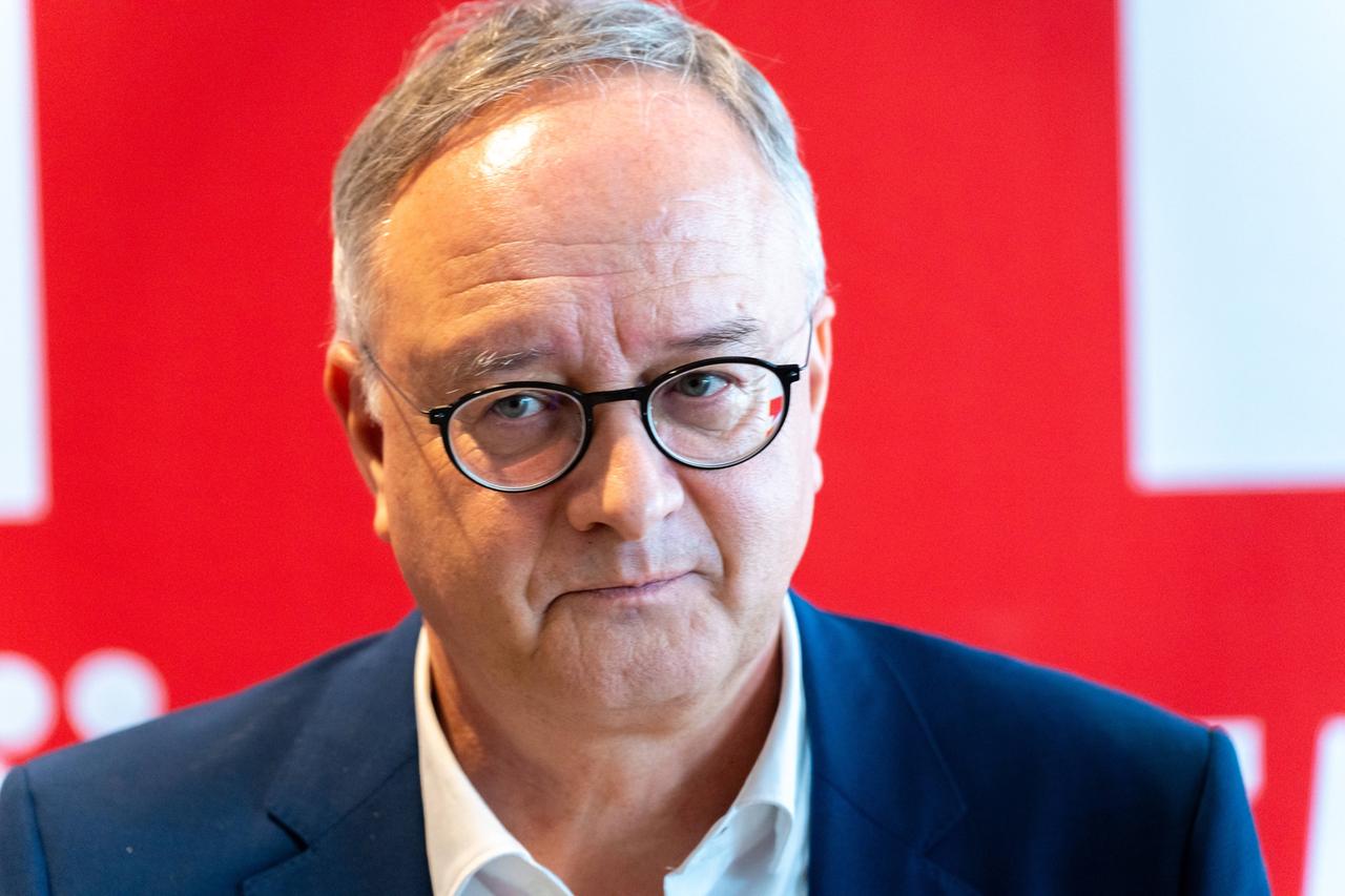 Portraitfoto von Andreas Stoch (SPD) vor rotem Hintergrund
