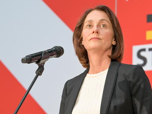 Katharina Barley an einem Mikrofon, nüchterner Gesichtsausdruck