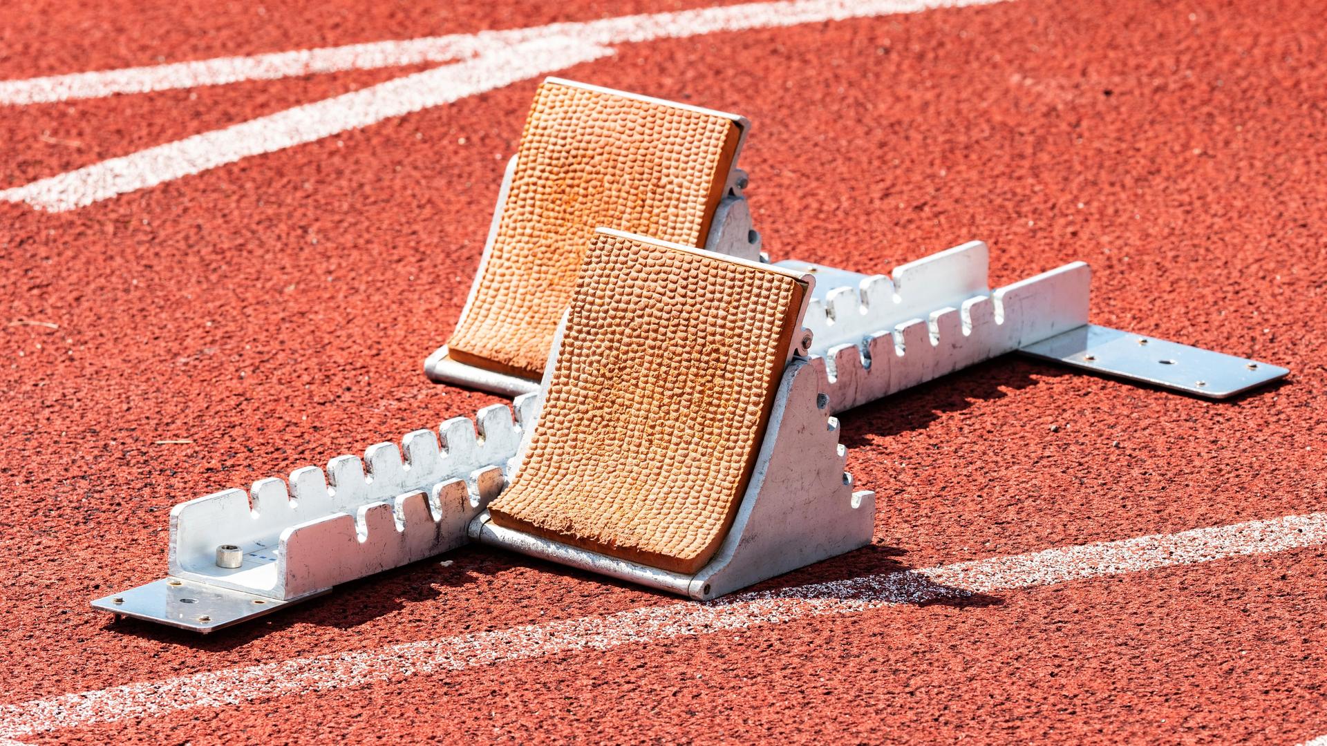 Leerer Startblock auf einer roten Laufbahn im Sportstadion. Leerer Startblock auf einer roten Laufbahn im Sportstadion.