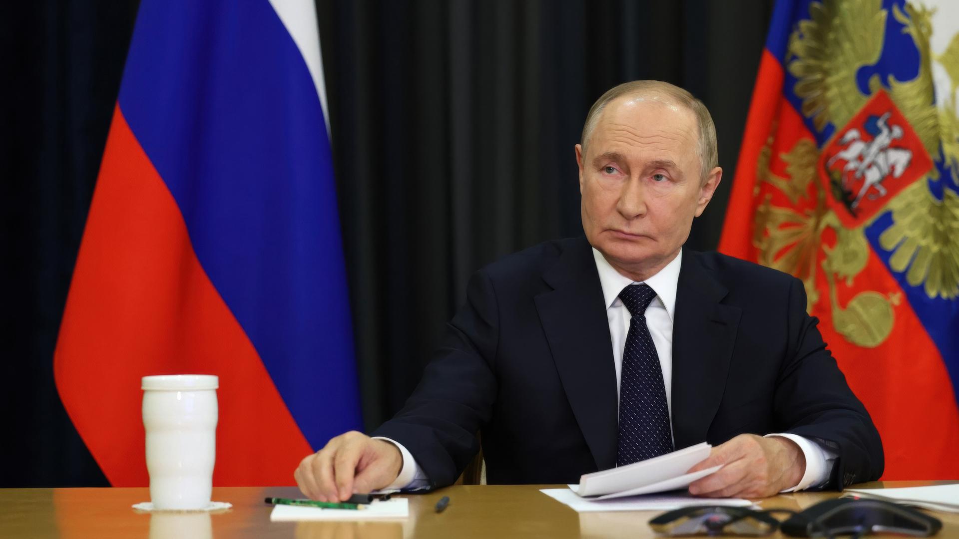 Russlands Präsident Wladimir Putin sitzt bei einem Video-Call am Schreibtisch. Russlands Präsident Wladimir Putin sitzt bei einem Video-Call am Schreibtisch.