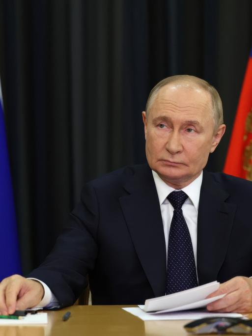 Russlands Präsident Wladimir Putin sitzt bei einem Video-Call am Schreibtisch.