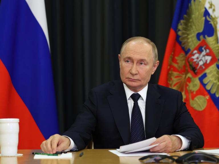 Russlands Präsident Wladimir Putin sitzt bei einem Video-Call am Schreibtisch.