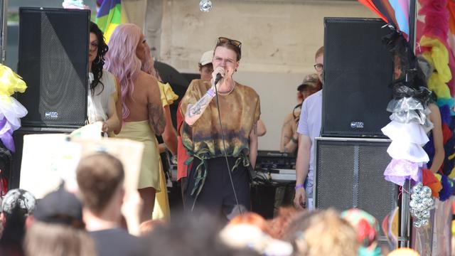 Luna Möbius steht auf der Bühne beim CSD in Leipzig und spricht am Mikrofon. Im Vordergrund steht das Publikum. 