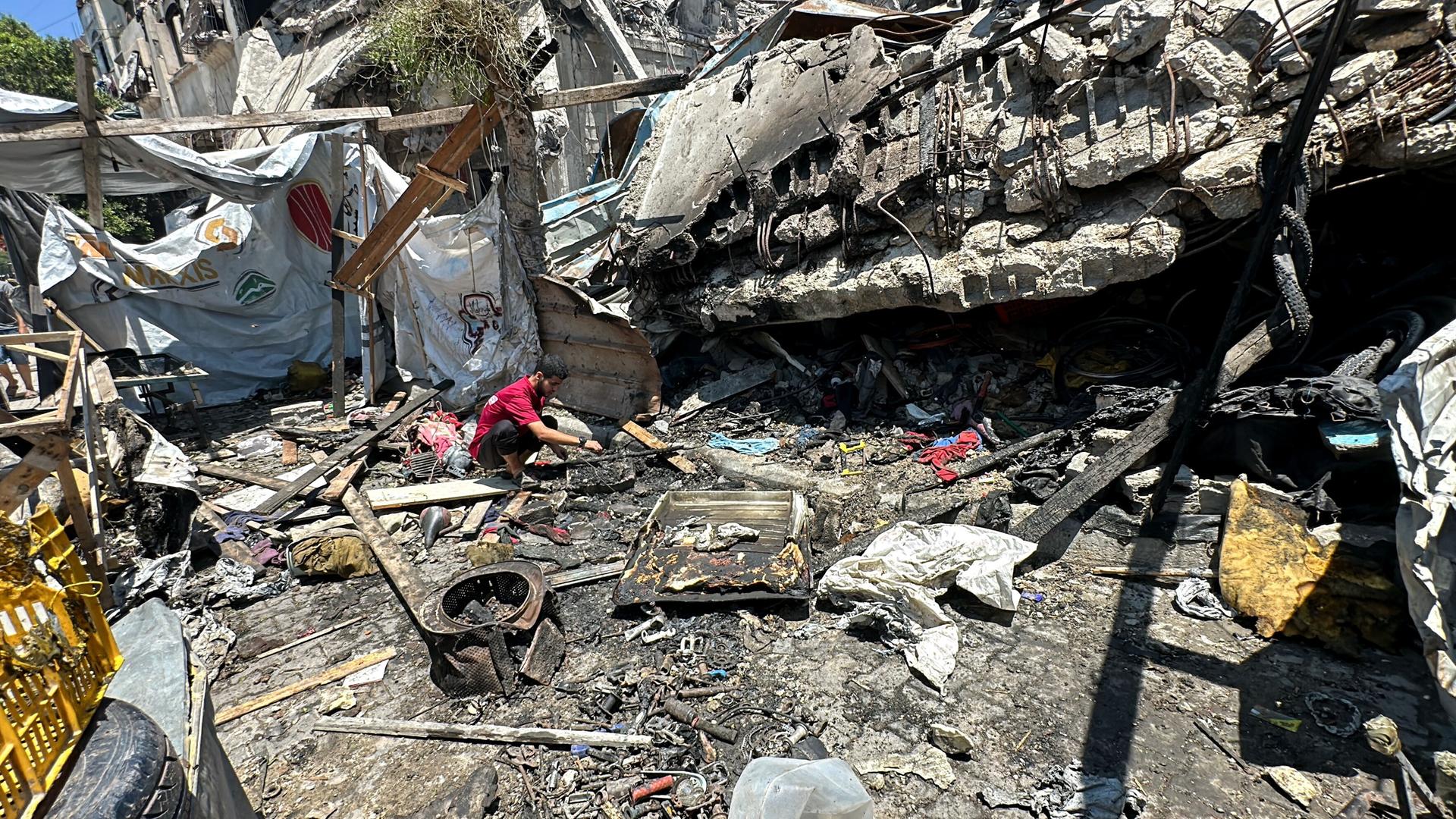 Ein Mann inspiziert ein völlig zerstörtes Camp im Gazastreifen.