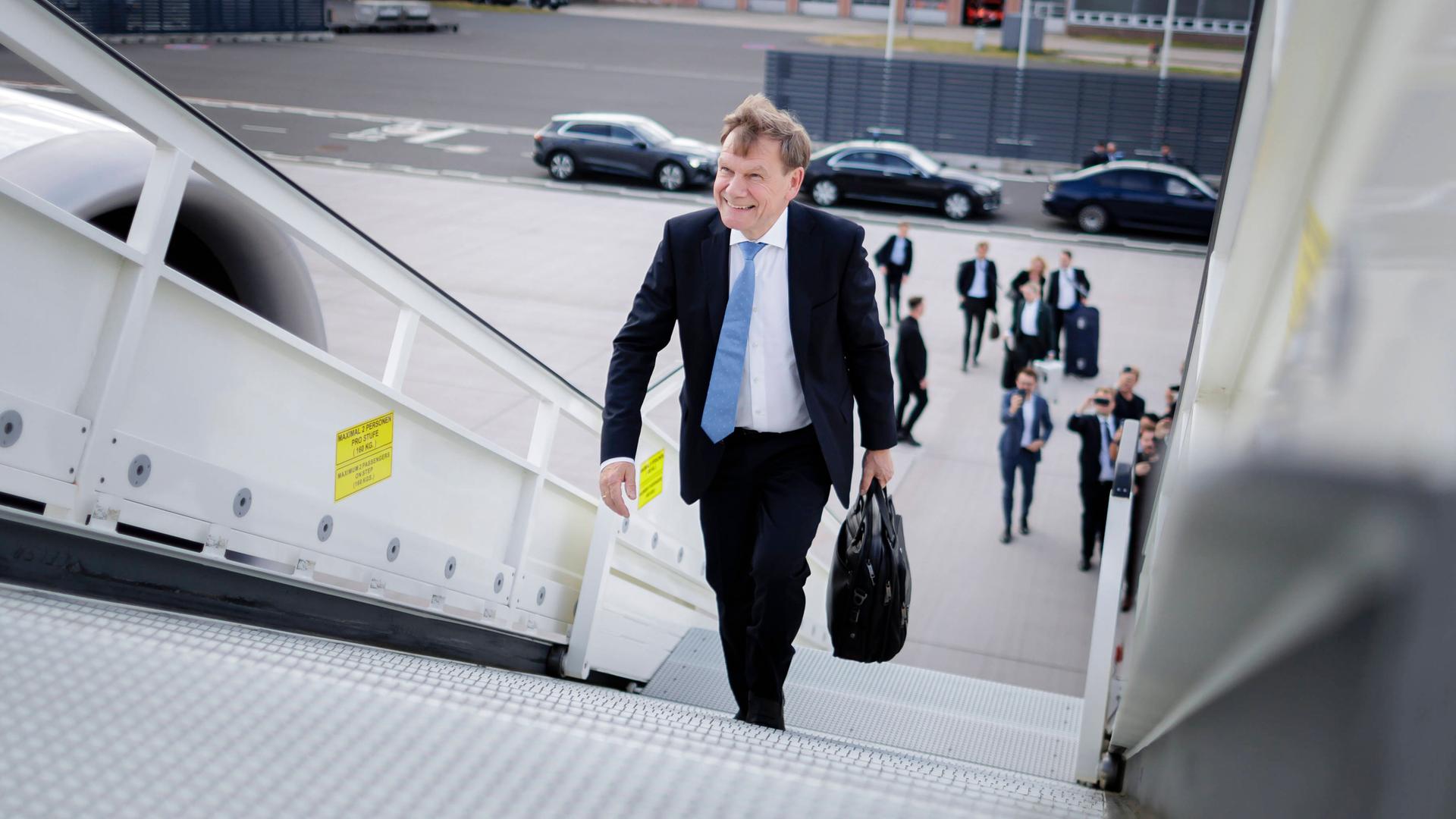 Bundesaußenminister Wadephul steigt in dunklem Anzug mit blauer Krawatte und einer Aktentasche in der linken Hand die Treppe eines Flugzeugs hinauf. Bundesaußenminister Wadephul steigt in dunklem Anzug mit blauer Krawatte und einer Aktentasche in der linken Hand die Treppe eines Flugzeugs hinauf.