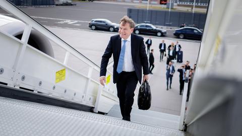 Bundesaußenminister Wadephul steigt in dunklem Anzug mit blauer Krawatte und einer Aktentasche in der linken Hand die Treppe eines Flugzeugs hinauf. 