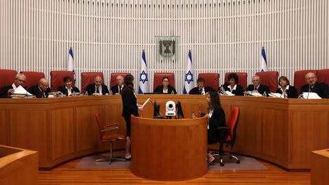 Richter sitzen auf einer Empore in den Räumlichkeiten des Obersten Gerichts in Jerusalem.