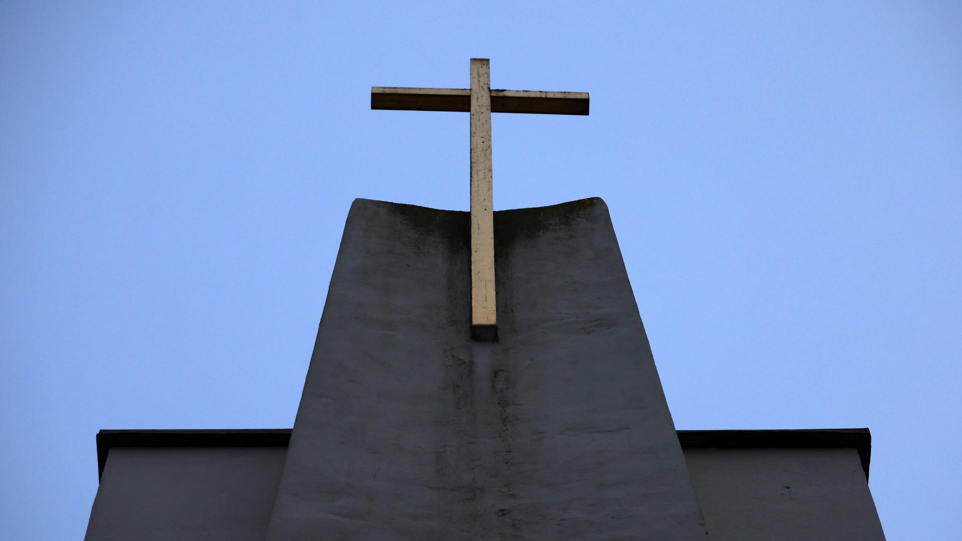 Die katholische Christuskirche in München. Ein Kreuz ist auf der Spitze von der Kirche zu sehen.