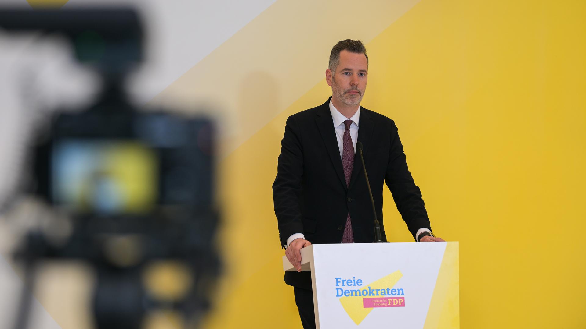 Der FDP-Fraktionsvorsitzende Christian Dürr  und ein Logo seiner Partei. 