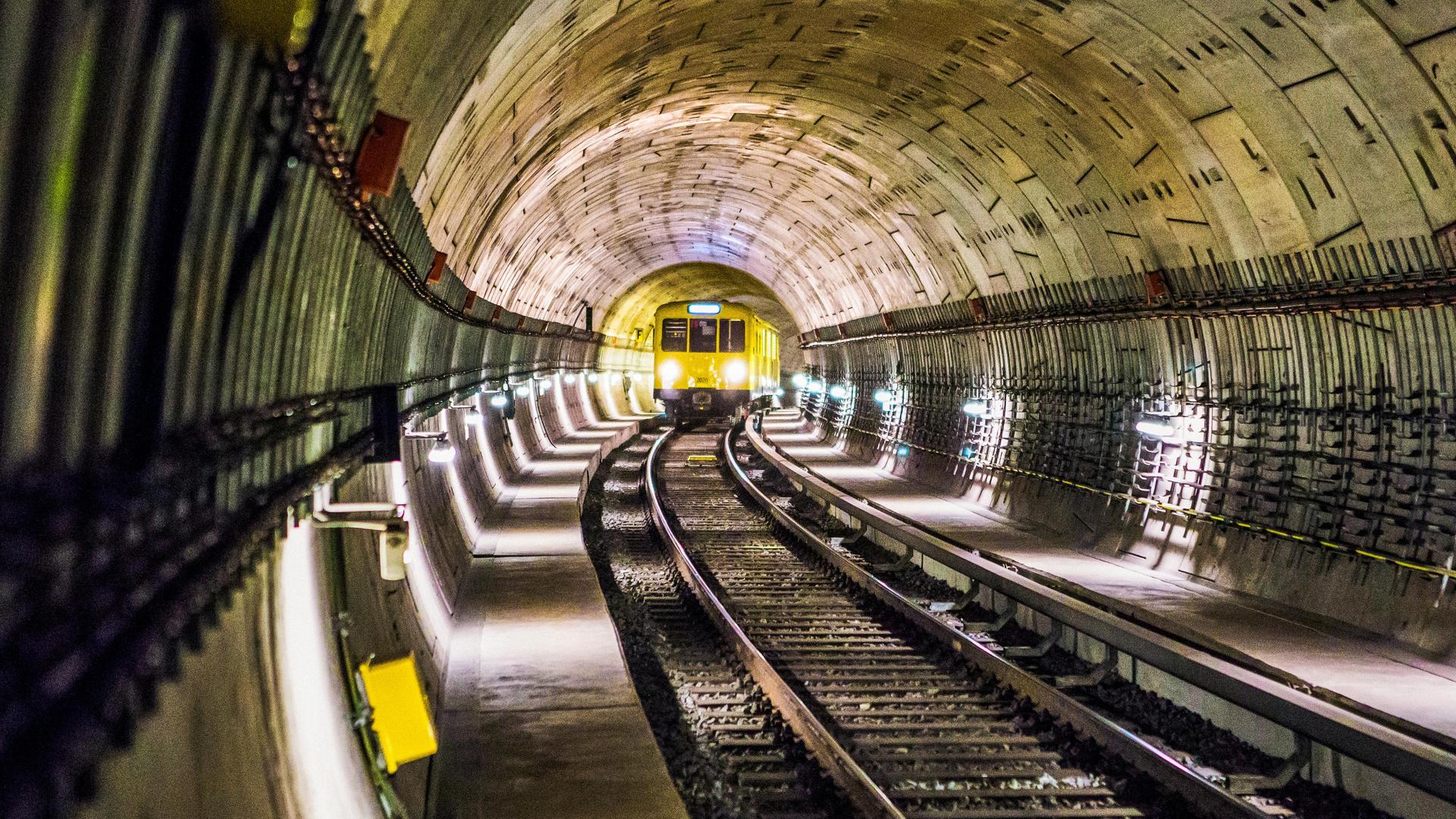 Blick in einen U-Bahn-Tunnel, in dem gerade in einer Kurve ein Zug auf die Kamera zufährt. Blick in einen U-Bahn-Tunnel, in dem gerade in einer Kurve ein Zug auf die Kamera zufährt.
