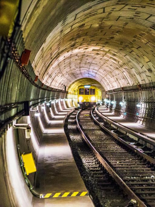 Blick in einen U-Bahn-Tunnel, in dem gerade in einer Kurve ein Zug auf die Kamera zufährt. Blick in einen U-Bahn-Tunnel, in dem gerade in einer Kurve ein Zug auf die Kamera zufährt.