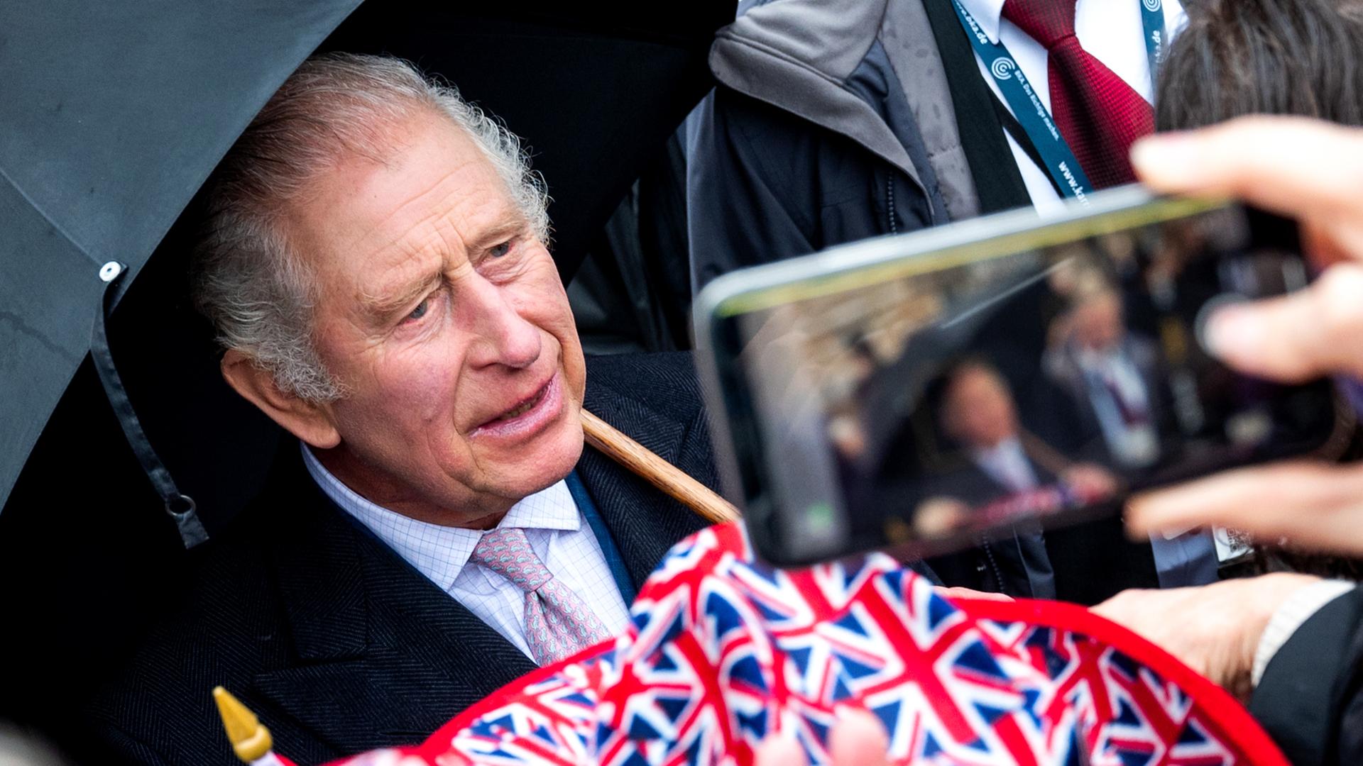 König Charles III. steht bei seinem Deutschlandbesuch in Hamburg vor Zuschauern mit Großbritannien-Flaggen 
