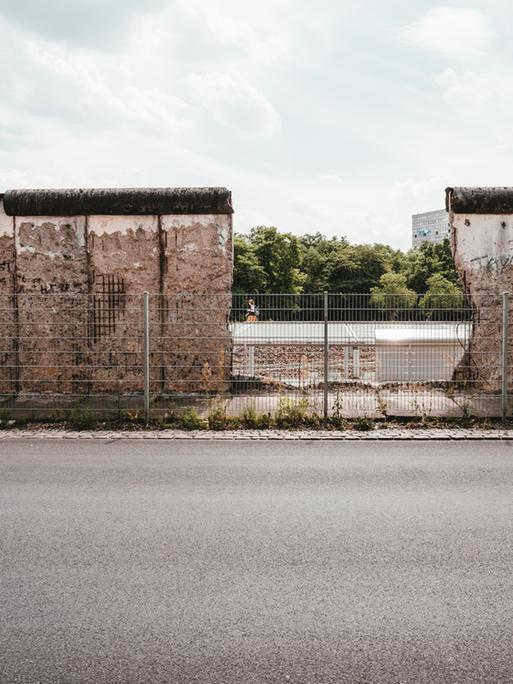 Blick auf ein Stück erhaltene Mauer, die in der Nähe des Berliner Gropiusbaus unterbrochen ist und den Blick frei gibt.