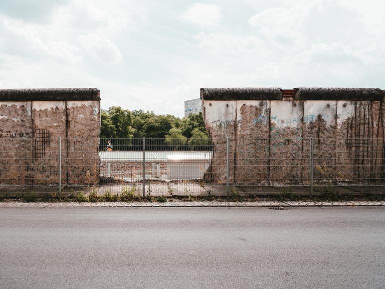 Blick auf ein Stück erhaltene Mauer, die in der Nähe des Berliner Gropiusbaus unterbrochen ist und den Blick frei gibt.