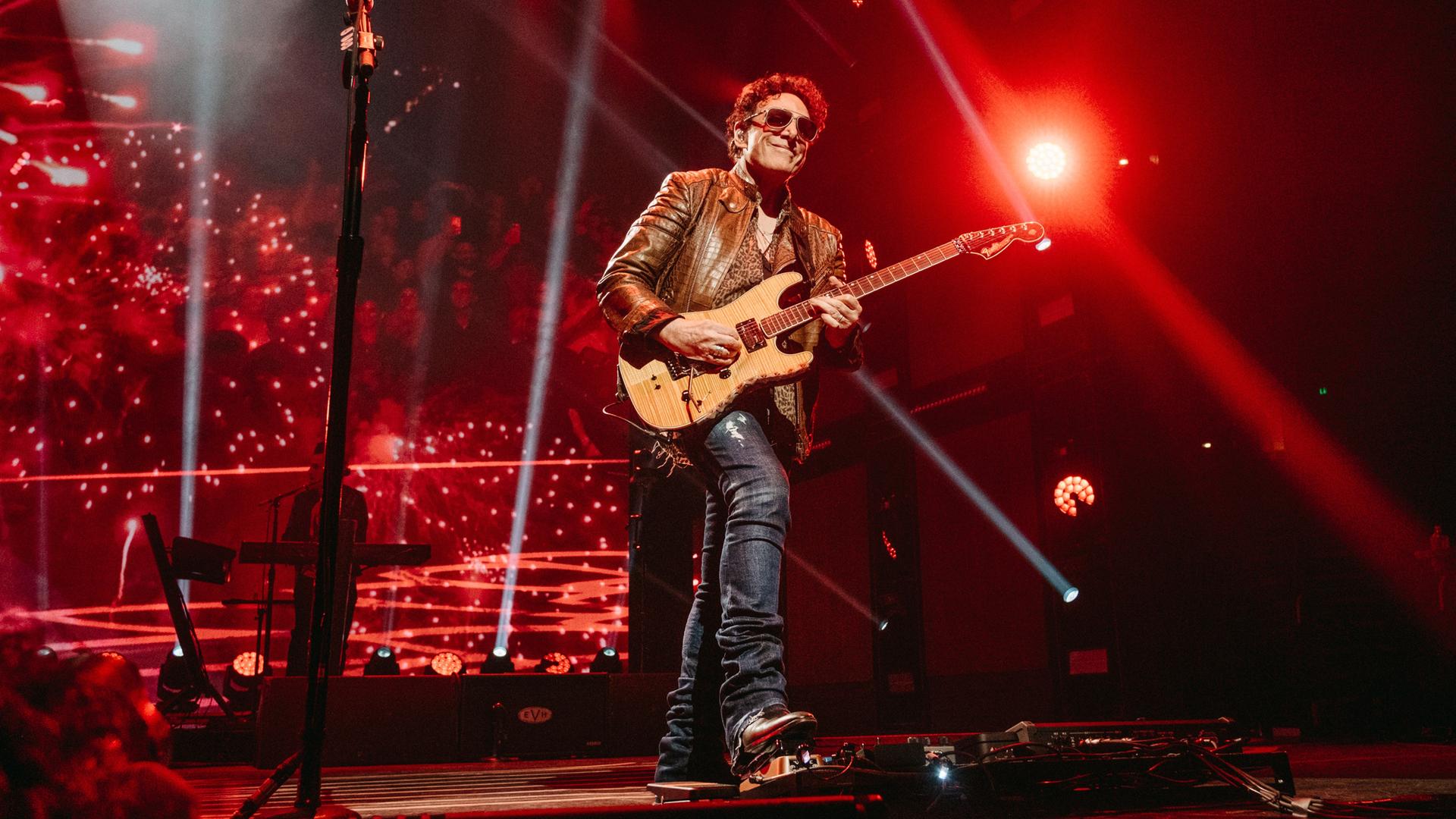 Journey-Konzert in Nashville. Der Gitarrist Neal Schon steht im roten Bühnenlicht. April 2022.