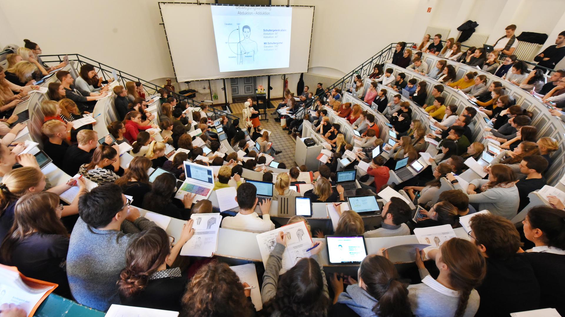In einem Anatomie-Hörsaal der Medizinischen Fakultät an der Martin-Luther-Universität Halle-Wittenberg verfolgen Medizin- und Zahnmedizinstudenten des ersten Studienjahres eine Vorlesung. 