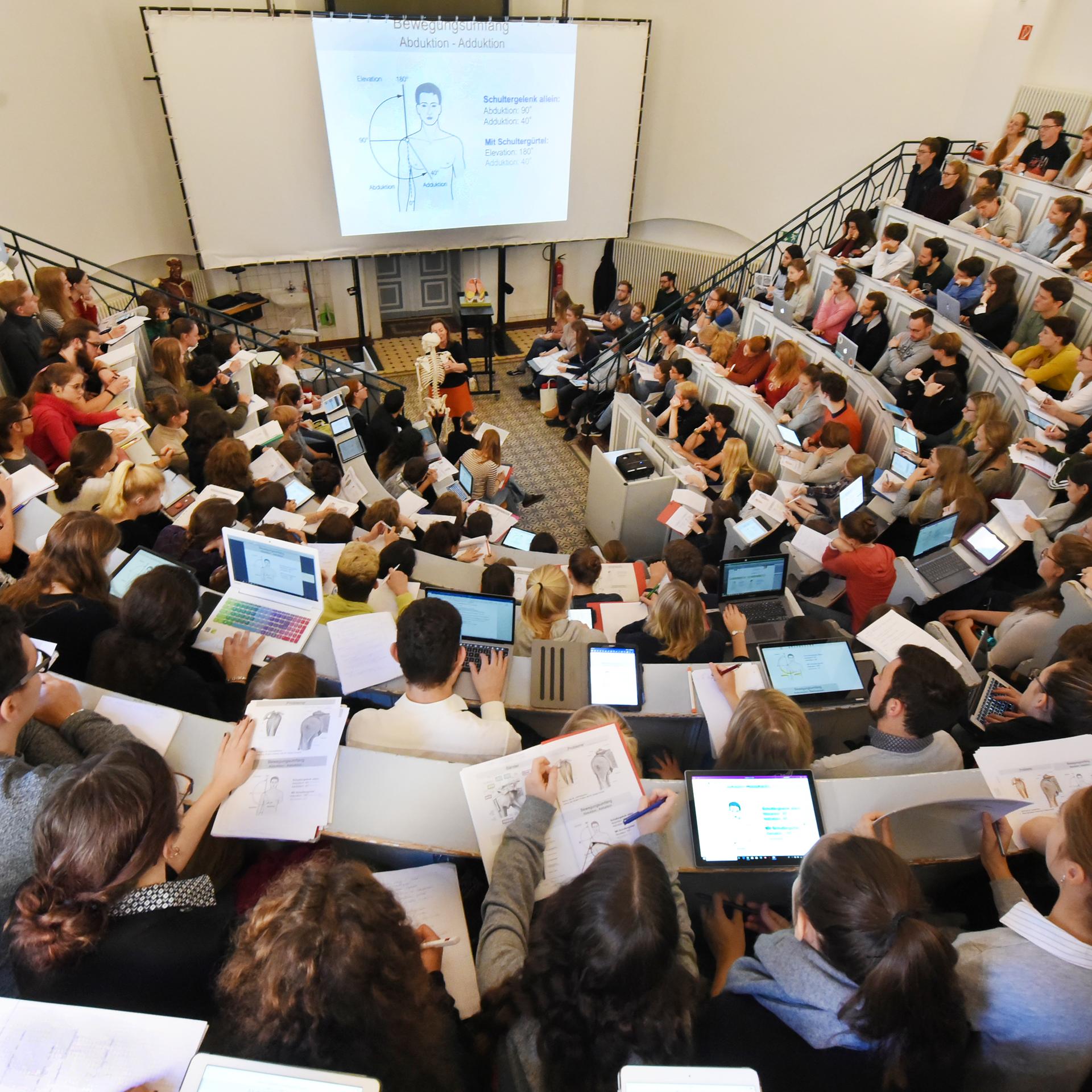 In einem Anatomie-Hörsaal der Medizinischen Fakultät an der Martin-Luther-Universität Halle-Wittenberg verfolgen Medizin- und Zahnmedizinstudenten des ersten Studienjahres eine Vorlesung. 