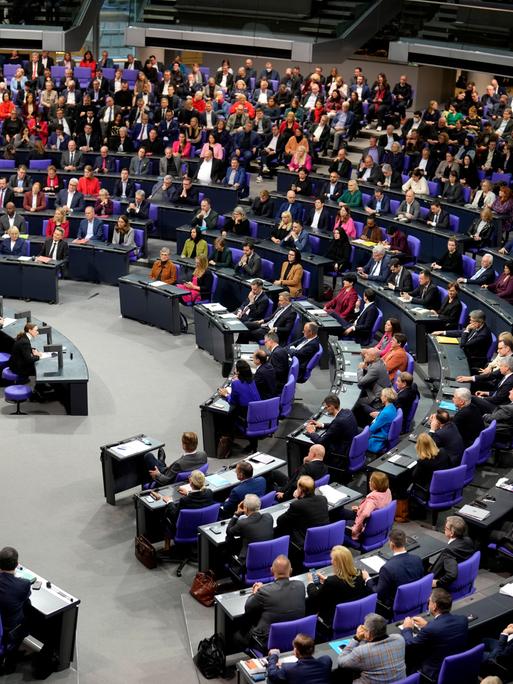 Bundeskanzler Scholz im Deutschen Bundestag, viele Abgeordnete sitzen auf ihren Plätzen. 