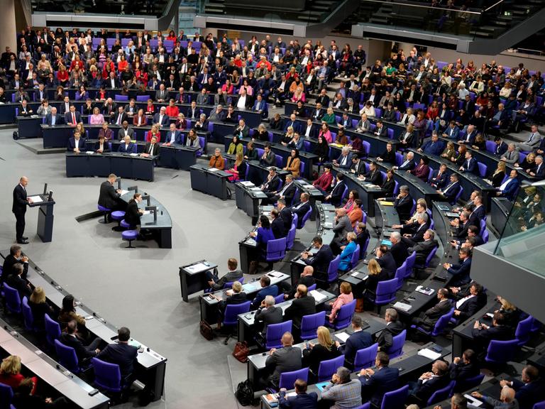 Bundeskanzler Scholz im Deutschen Bundestag, viele Abgeordnete sitzen auf ihren Plätzen. 