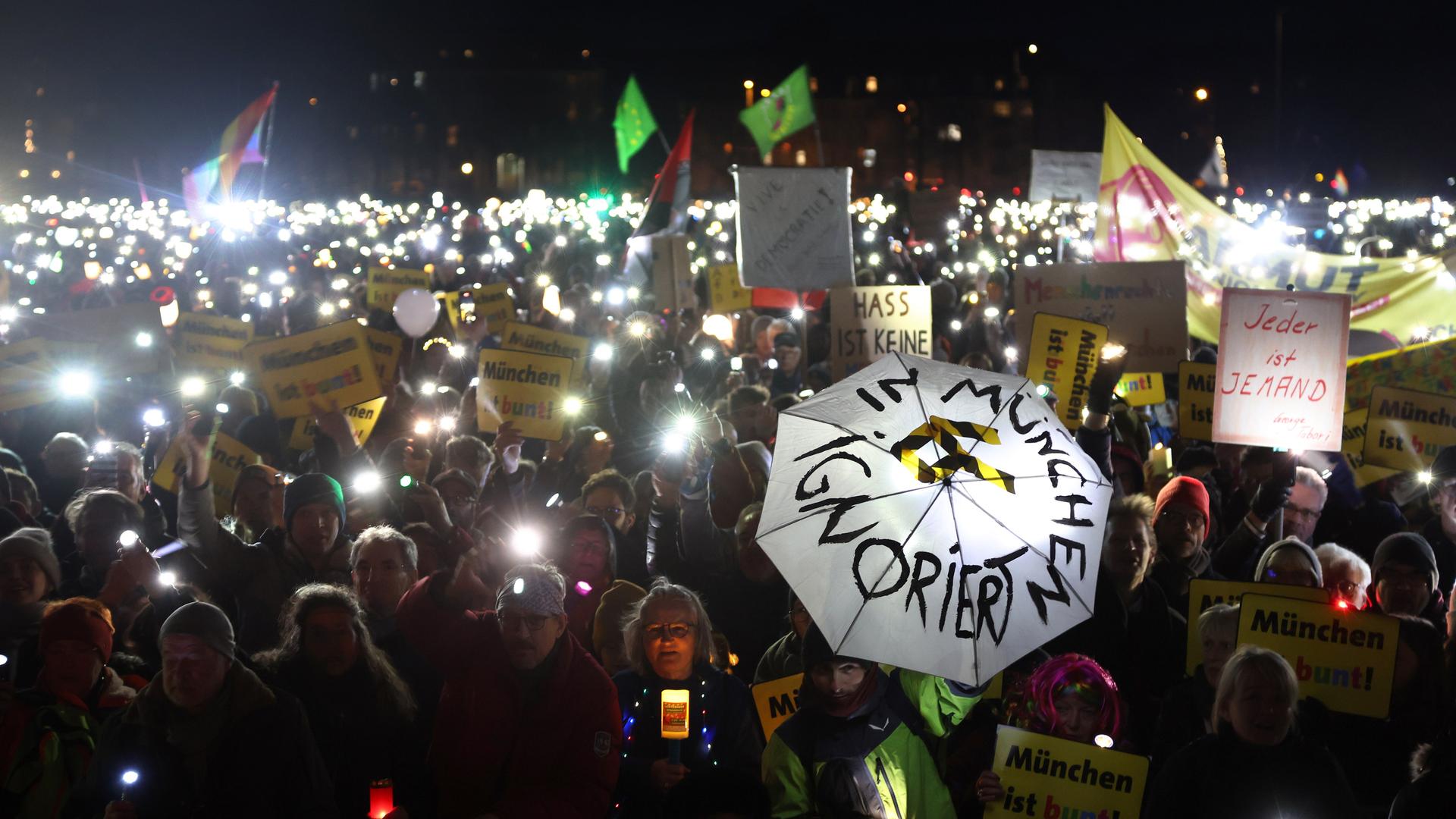 Menschen stehen bei einer Demonstration unter dem Motto «Lichtermeer für Demokratie, gegen Rassismus, Antisemitismus und Hetze» auf der Theresienwiese. Es ist dunkel; viele leuchten mit Taschenlampen. Menschen stehen bei einer Demonstration unter dem Motto «Lichtermeer für Demokratie, gegen Rassismus, Antisemitismus und Hetze» auf der Theresienwiese. Es ist dunkel; viele leuchten mit Taschenlampen.