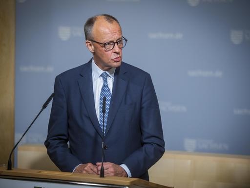 Bundeskanzler Friedrich Merz steht an einem Rednerpult und schaut zur Seite Bundeskanzler Friedrich Merz steht an einem Rednerpult und schaut zur Seite