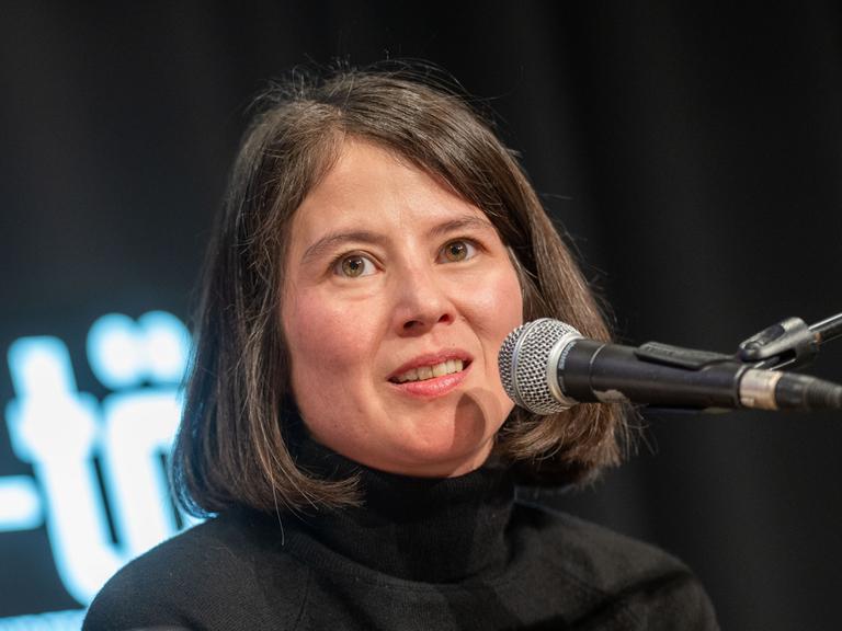 Die Autorin Milena Michiko Flasar spricht auf einer Bühne an einem Mikrofon