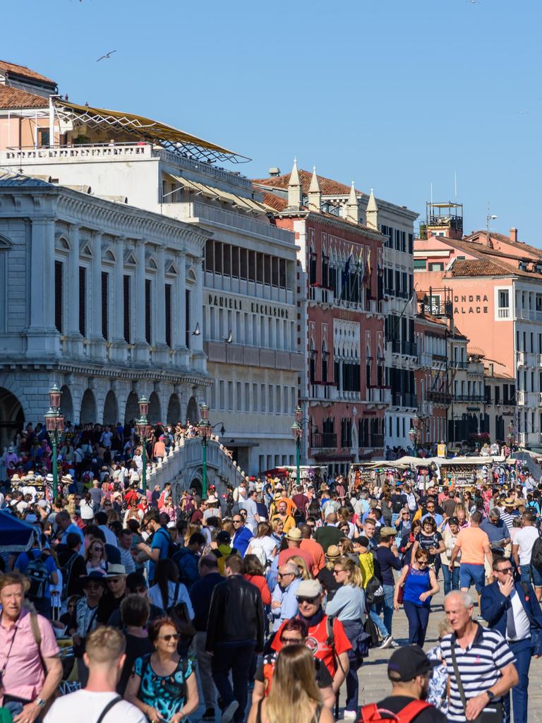 Sehr viele Menschen sind bei Sonnenschein auf einem Platz in Venedig zu sehen.