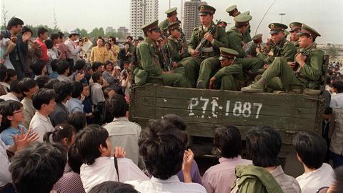 Demonstranten auf dem Tiananmen-Platz umringen einen Panzer mit Soldaten der Volksbefreiungsarmee.