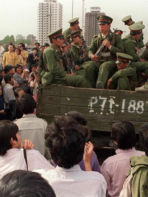 Demonstranten auf dem Tiananmen-Platz umringen einen Panzer mit Soldaten der Volksbefreiungsarmee.