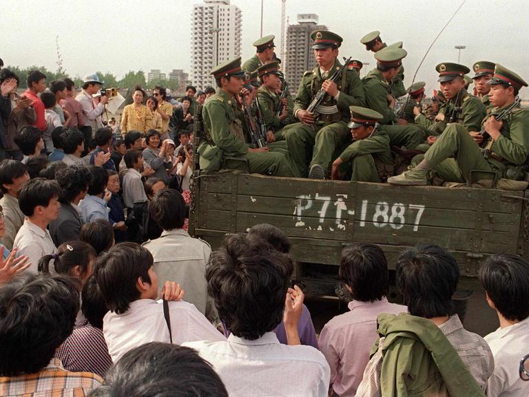 Demonstranten auf dem Tiananmen-Platz umringen einen Panzer mit Soldaten der Volksbefreiungsarmee.