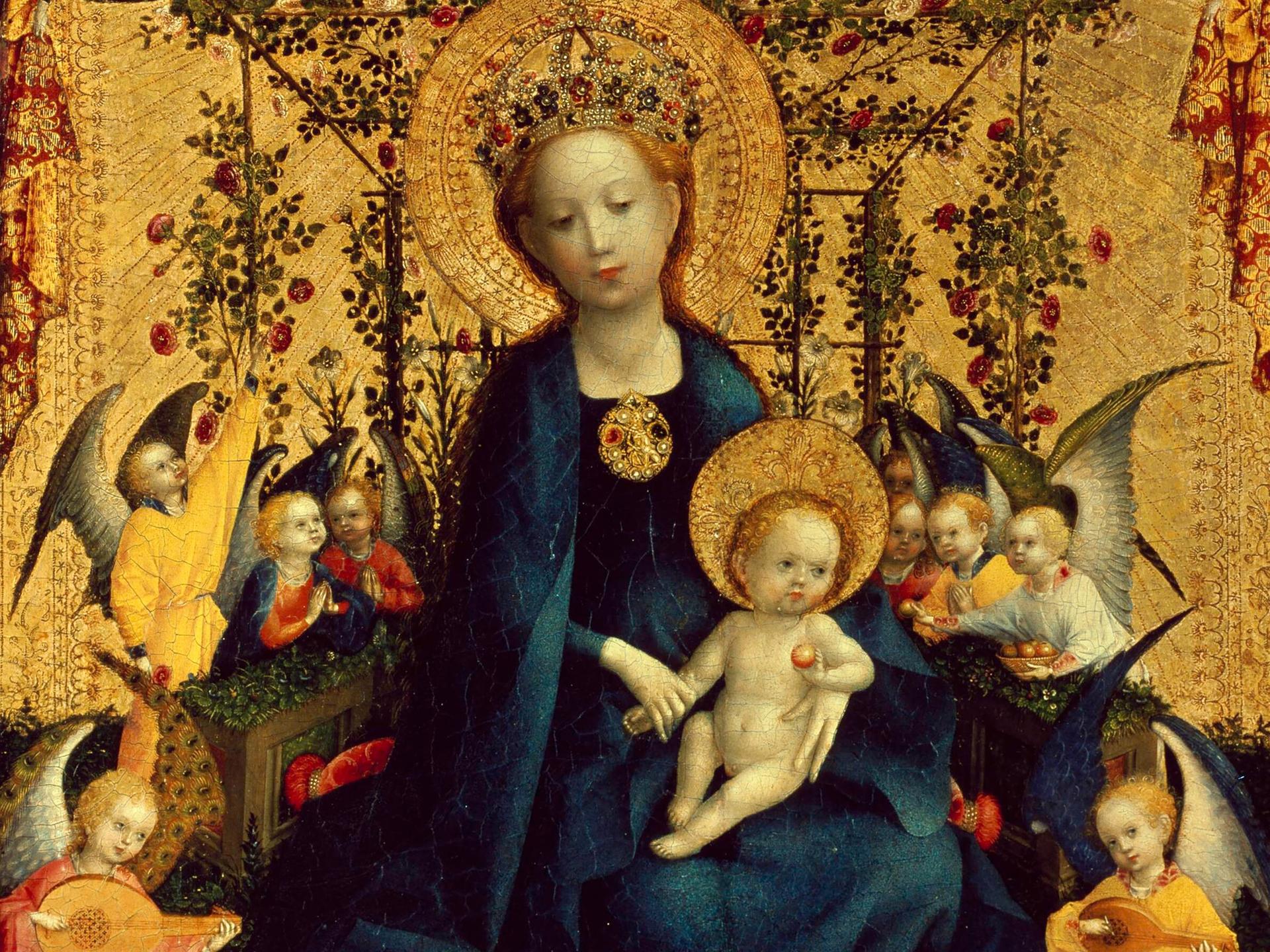 Das Bild "Muttergottes in der Rosenlaube" von Stephan Lochner zeigt ein Ölgemälde von Maria mit Jesus auf dem Schoß. Sie trägt ein blaues Gewand, Jesus ist nackt.