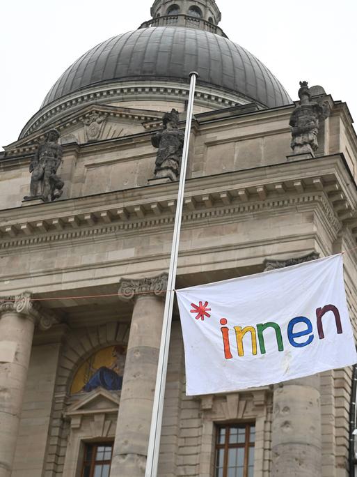 Schülerinnen und Schüler haben eine Flagge mit der Aufschrift "innen" in Regenbogenfarben an der Münchner Staatskanzlei angebracht. 3. April 2024