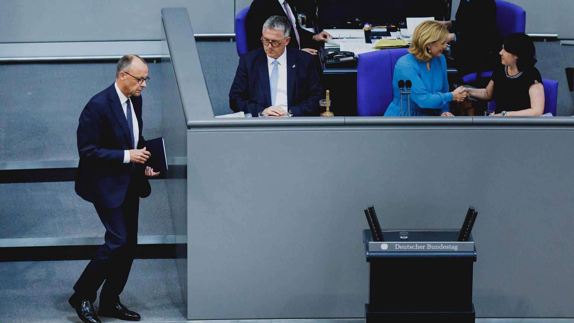 Das Bild zeigt Friedrich Merz, während er im Plenarsaal des Bundestags zum Rednerpult geht. 