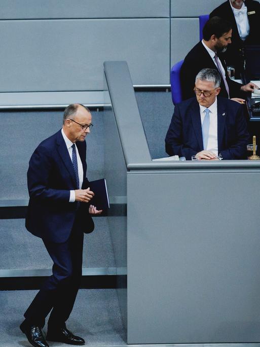 Das Bild zeigt Friedrich Merz, während er im Plenarsaal des Bundestags zum Rednerpult geht. 