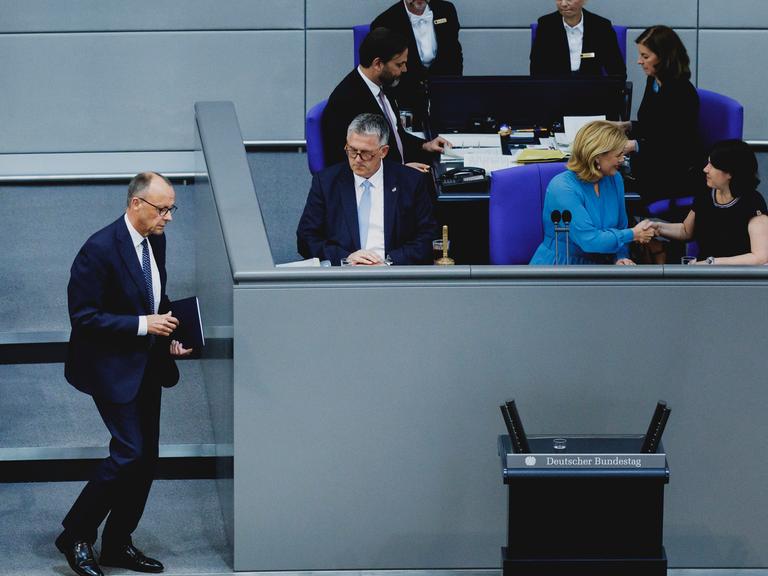 Das Bild zeigt Friedrich Merz, während er im Plenarsaal des Bundestags zum Rednerpult geht. 