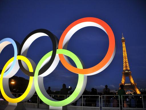 Die Olympischen Ringe werden vor dem Pariser Eifelturm angestrahlt. 