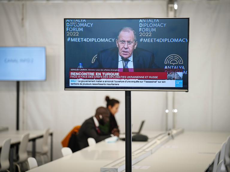 Auf einem Fernseher im Pressezentrum am Schloss in Versailles läuft die Übertragung der Pressekonferenz von Sergei Lawrow, Außenminister von Russland, nach dessen Treffen mit seinem ukrainischen Amtskollegen.