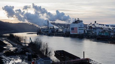 Die Kokerei Clairton von U. S. Steel liegt am Monongahela River in Clairton. Rauch steigt aus den Schornsteinen, an der Fassade des Gebäudes ist eine haushohe US-Flagge zu sehen.