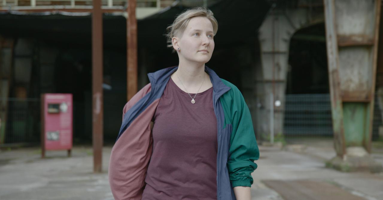 Ann Catherine Meyer geht lächelnd mit offener Jacke über ein Werksgelände Ann Catherine Meyer geht lächelnd mit offener Jacke über ein Werksgelände