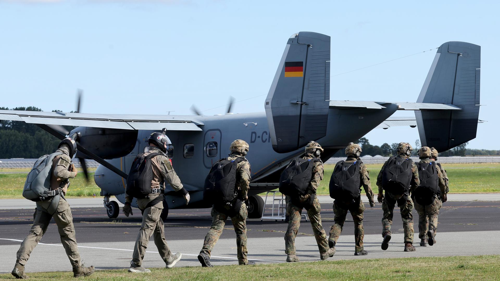 Fallschirmjäger steigen in ein Flugzeug. 