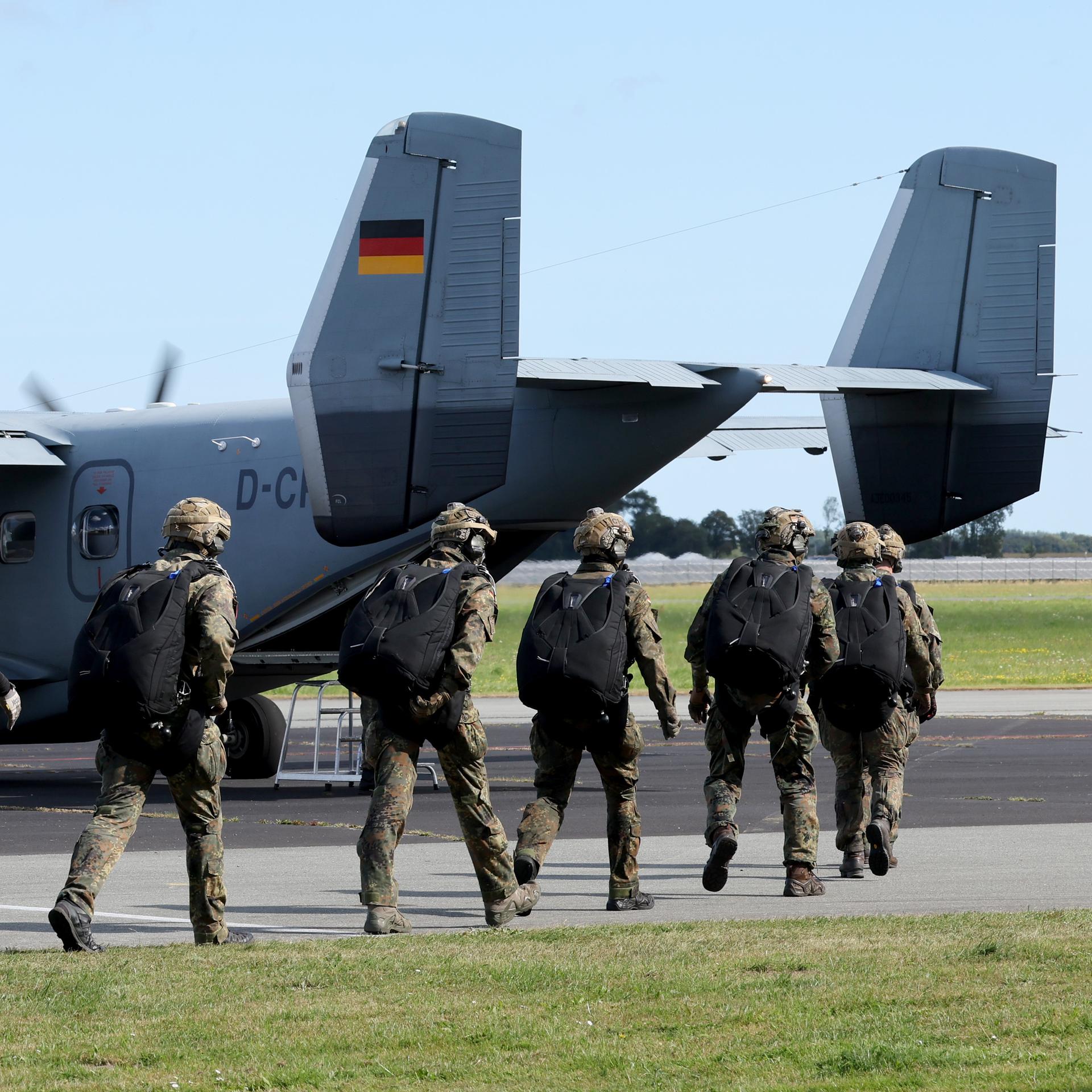 Fallschirmjäger steigen in ein Flugzeug. 