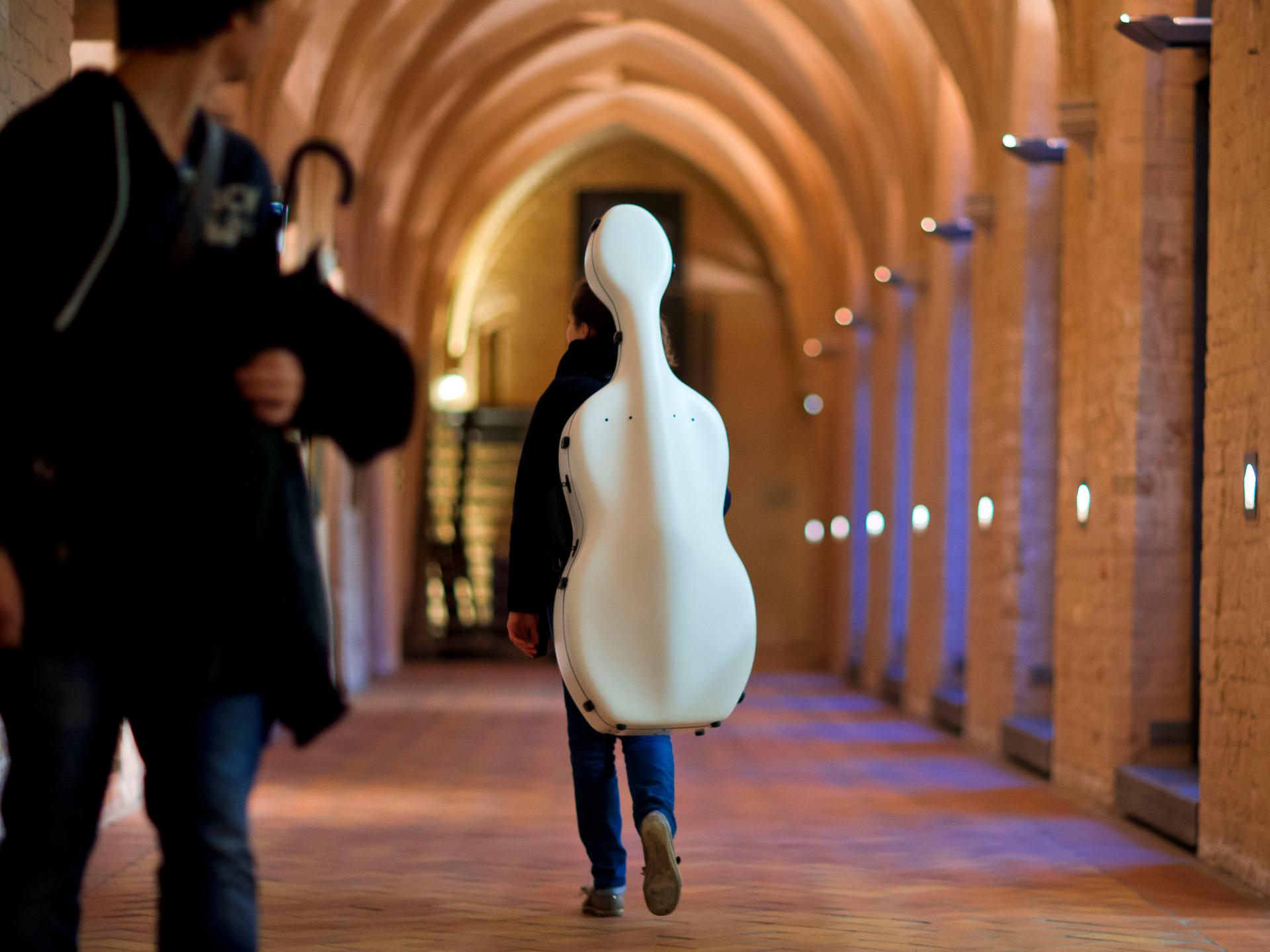 Eine Studentin der Hochschule für Musik und Theater in Rostock (Mecklenburg-Vorpommern) trägt ihr Cello durch einen Kreuzgang des Katharinenstifts.