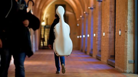 Eine Studentin der Hochschule für Musik und Theater in Rostock (Mecklenburg-Vorpommern) trägt ihr Cello durch einen Kreuzgang des Katharinenstifts.