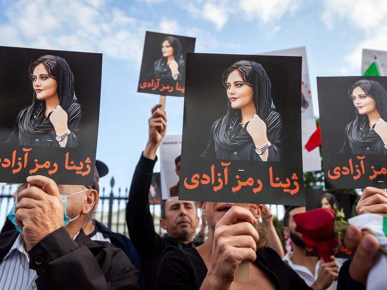 Demonstranten halten Schilder mit dem Bild von Mahsa Amini in die Höhe