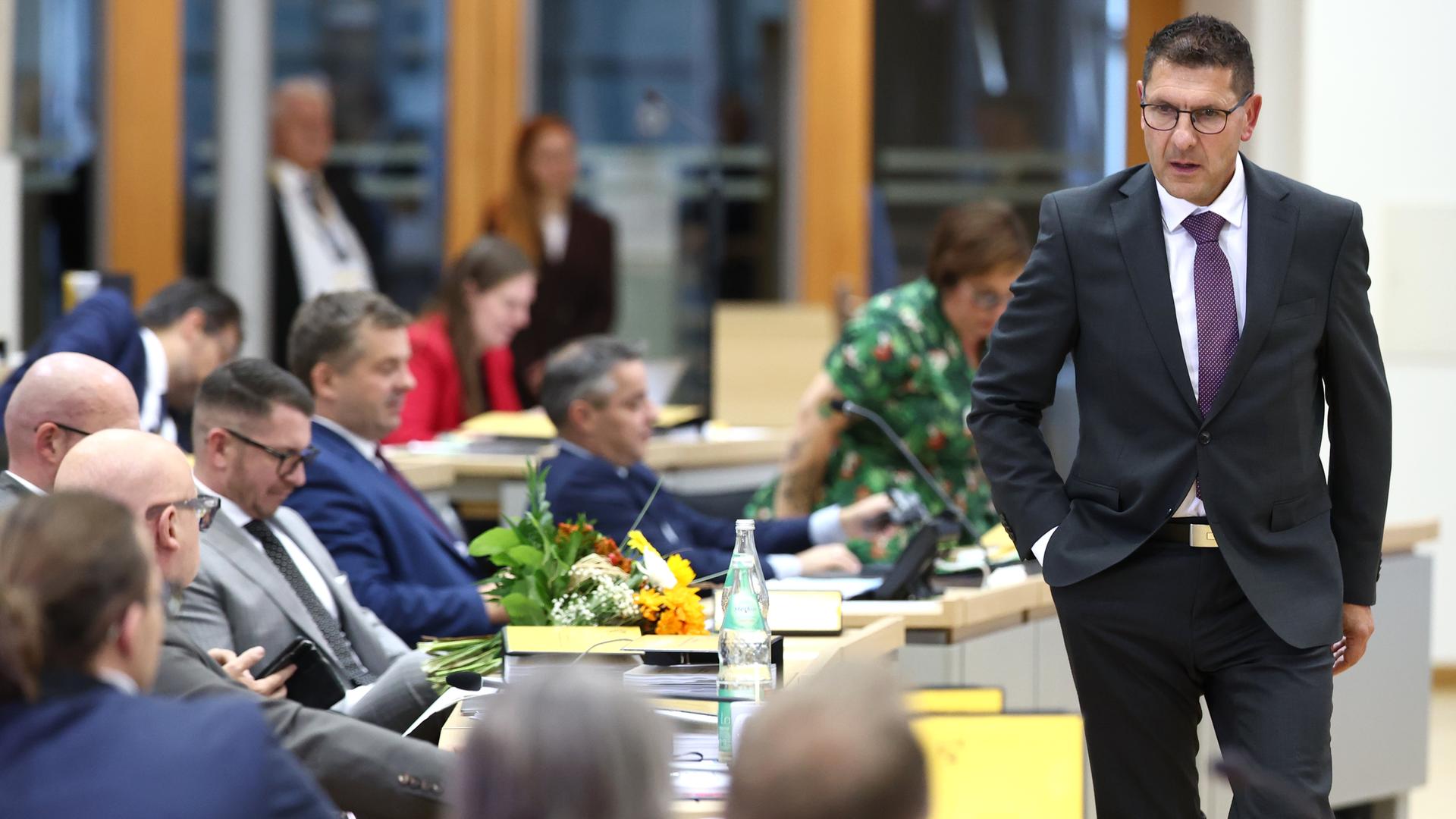 Thomas Schulze (BSW), geht während der konstituierenden Sitzung des Landtags in Sachsen-Anhalt an den Abgeordneten der AfD entlang.