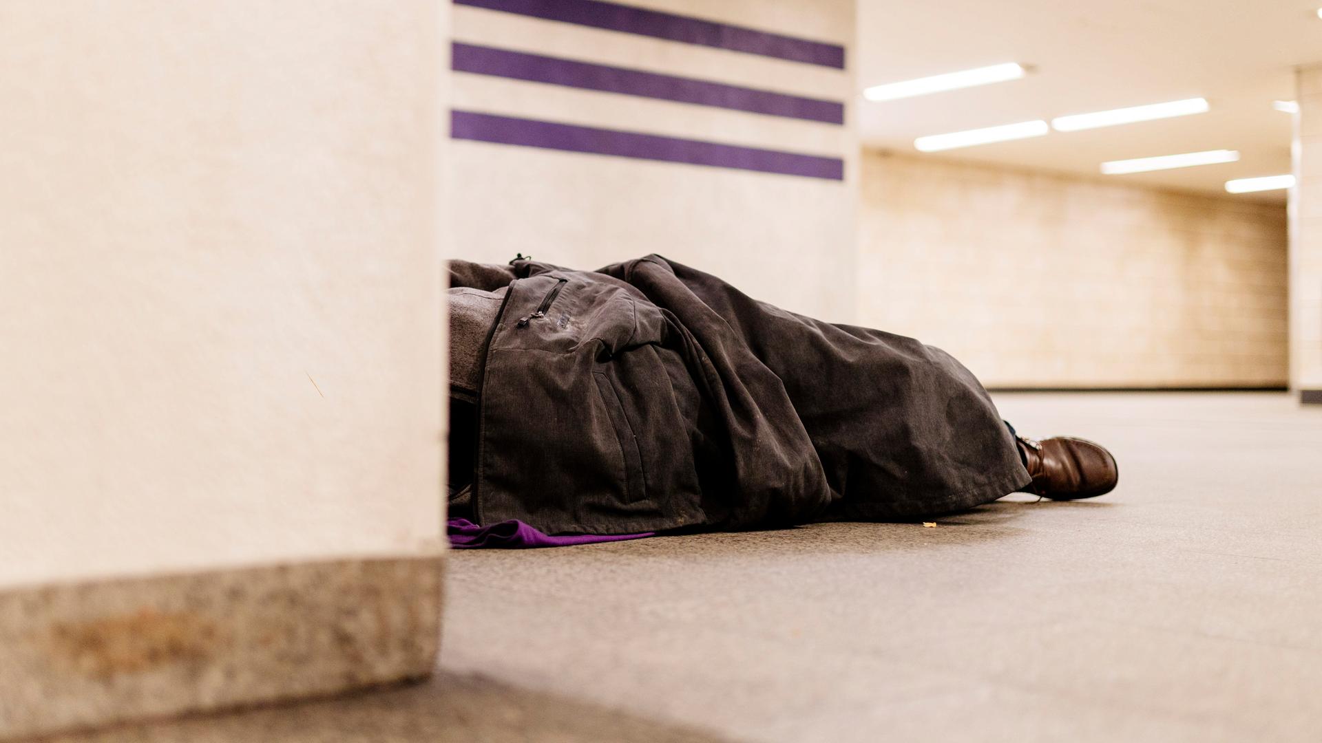 Ein Obdachloser schläft improvisiert unter einer Decke in einer U-Bahn-Haltestelle. Köln, 04.12.2019